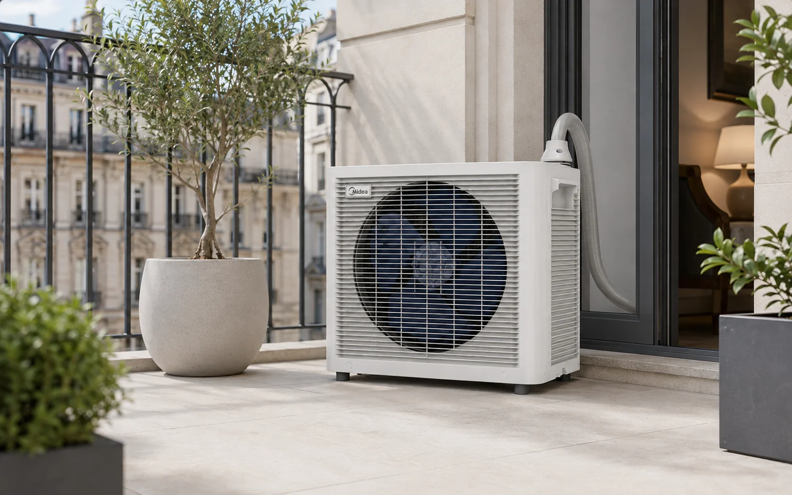 Unité extérieure du PortaSplit posée au sol sur un balcon, à côté de la porte-fenêtre, grille dégagée pour évacuer l'air chaud