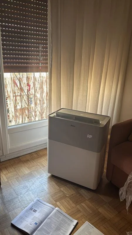Le PortaSplit posé devant une fenêtre à volet, dans un salon aux rideaux clairs